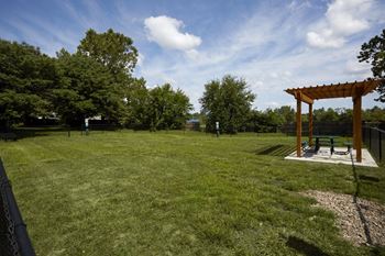 A park with a wooden pergola and bench.